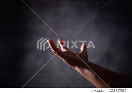 Christian woman lifts her hand in worship to pray, hope, faith, and deep belief in God defines core concept of religion. Praying hands with faith in religion, belief in God. Power of hope or love. Christian woman lifts her hand in worship to pray, hope, faith, and deep belief in God defines core concept of religion. Praying hands with faith in religion, belief in God. Power of hope or love. 128775994