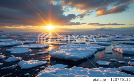 Stunning sunset over broken sea ice, reflecting warm colors on water surface, creating serene atmosphere Stunning sunset over broken sea ice, reflecting warm colors on water surface, creating serene atmosphere 128776136