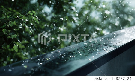 手すりに叩きつける激しい雨粒、スコール 128777124