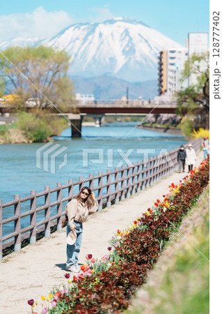 Woman tourist sightseeing Iwate mountain and Kitakami river with flowers in Spring, happy traveler travel in Morioka city, Iwate prefecture, Japan. famous Landmark Travel and Vacation destination Woman tourist sightseeing Iwate mountain and Kitakami river with flowers in Spring, happy traveler travel in Morioka city, Iwate prefecture, Japan. famous Landmark Travel and Vacation destination 128777402