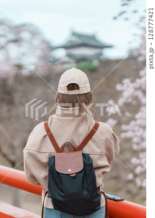 Woman tourist sightseeing Hirosaki Castle with Sakura Cherry Blossom in Spring, happy traveler travel in Hirosaki city, Aomori, Tohoku, Japan. Landmark famous in Japan. Travel and Vacation destination 128777421