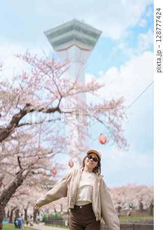 Woman tourist sightseeing Goryokaku Tower park with Sakura Cherry Blossom in Spring, happy traveler travel in Hakodate city, Hokkaido, Japan. famous Landmark, Japan Travel and Vacation destination 128777424