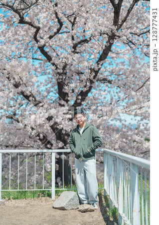 man tourist sightseeing Sakura Cherry blossom at Morioka Castle Ruins park in Spring, happy traveler travel in Iwate Park, Iwate prefecture, Japan. famous Landmark Travel and Vacation destination 128777431