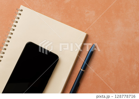 リングノートとスマホとペンを並べたデスク構成 リングノートとスマホとペンを並べたデスク構成 128778716