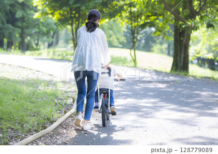 自転車に乗る練習をする親子 128779089