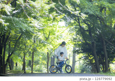 自転車に乗る練習をする親子 128779092