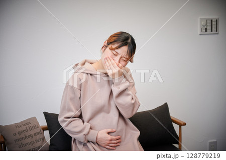 つわりに苦しむ女性　妊婦　マタニティ 128779219