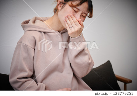 つわりに苦しむ女性　妊婦　マタニティ 128779253