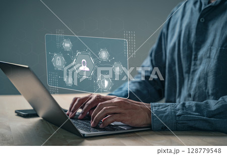 Cyber security focuses on data protection as a person uses a laptop to login Cyber security focuses on data protection as a person uses a laptop to login 128779548