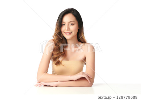 A beautiful young Asian woman with clean, fresh skin against a white background. Skincare, facial treatment, cosmetology, beauty, and spa. An elegant portrait of an Asian woman. 128779689