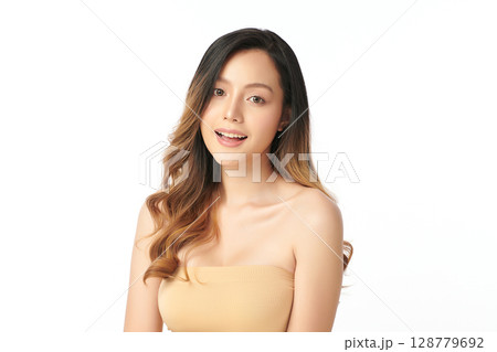 A beautiful young Asian woman with clean, fresh skin against a white background. Skincare, facial treatment, cosmetology, beauty, and spa. An elegant portrait of an Asian woman. 128779692