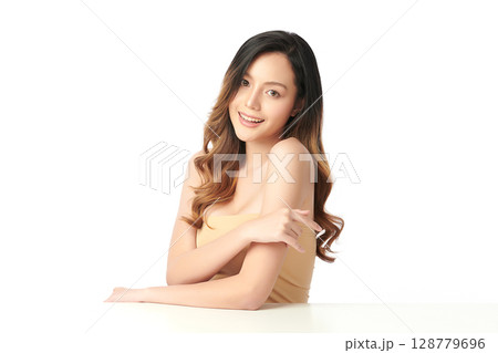 A beautiful young Asian woman with clean, fresh skin against a white background. Skincare, facial treatment, cosmetology, beauty, and spa. An elegant portrait of an Asian woman. 128779696