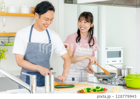 キッチンに立つ若い夫婦 128779943