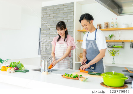 キッチンに立つ若い夫婦 128779945