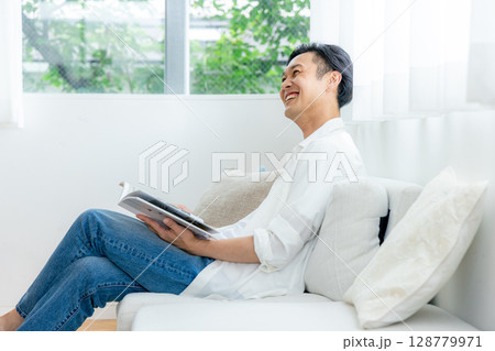 ソファーで読書をする男性 128779971
