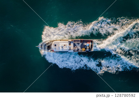 Fishing boat sailing in the sea 128780592