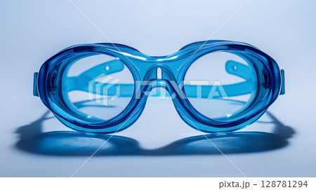 Blue swimming goggles on reflective surface. 128781294