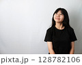 Cute Asian girl in black t-shirt, Looking Up and Slightly Smiling 128782106