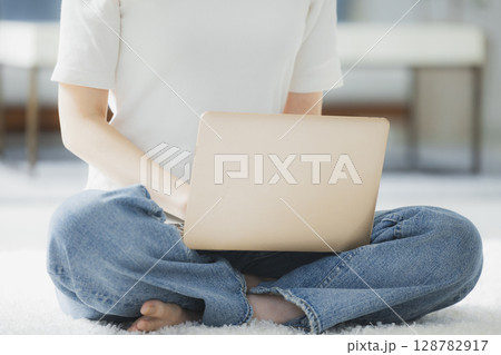 リビングでパソコンを使う若い女性 リビングでパソコンを使う若い女性 128782917