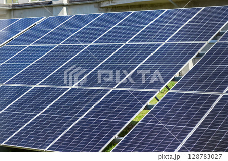 Expansive array of dark blue solar panels capturing sunlight, illustrating sustainable energy generation and a commitment to environmental protection efforts Expansive array of dark blue solar panels capturing sunlight, illustrating sustainable energy generation and a commitment to environmental protection efforts 128783027