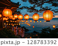a traditional Obon dance performed at night, participants wearing yukatas dancing in a circle under glowing lanterns, a serene evening sky enhancing the scene 128783392
