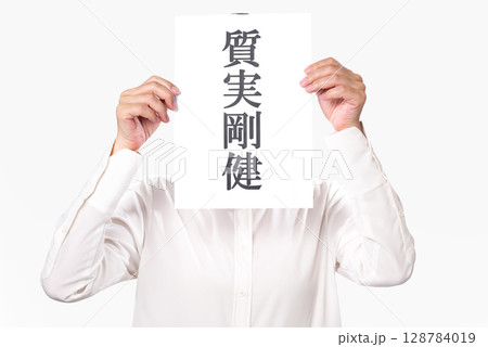 質実剛健と書かれた紙を持つ白いシャツを着た人物 質実剛健と書かれた紙を持つ白いシャツを着た人物 128784019