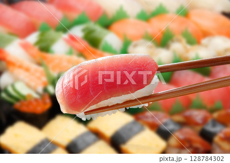 マグロの握りを箸で持ち上げたシズル感のある一枚 128784302