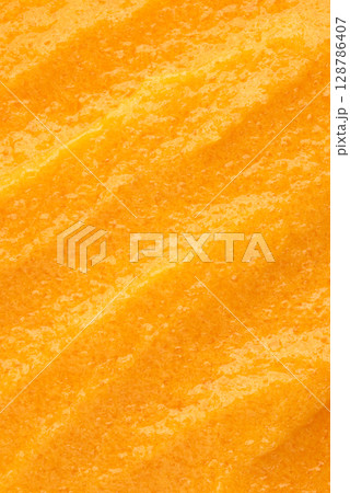 The texture of a orange body scrub with particles. Close-up The texture of a orange body scrub with particles. Close-up 128786407