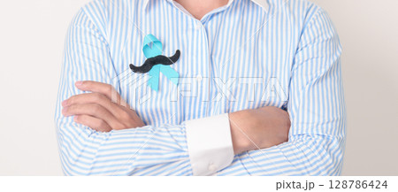 Man with blue Ribbon and mustache for Blue November, November Prostate Cancer Awareness month, World Diabetes day , Men Health month, International men, Father day. Healthcare and world cancer day Man with blue Ribbon and mustache for Blue November, November Prostate Cancer Awareness month, World Diabetes day , Men Health month, International men, Father day. Healthcare and world cancer day 128786424