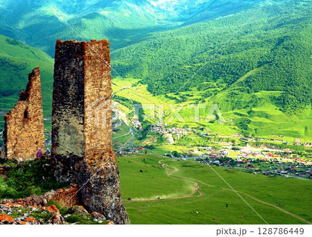 Ancient architecture and ruins against mountain background . Remains of a destroyed tower . North Ossetia-Alania , Russia 128786449