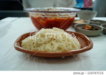 Traditional Korean spicy cold raw fish soup (Mulhoe) served with somen noodles on the side 128787518