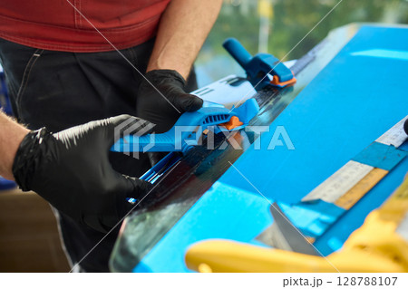A skilled craftsman is diligently using various tools to achieve precision work on a blue project A skilled craftsman is diligently using various tools to achieve precision work on a blue project 128788107