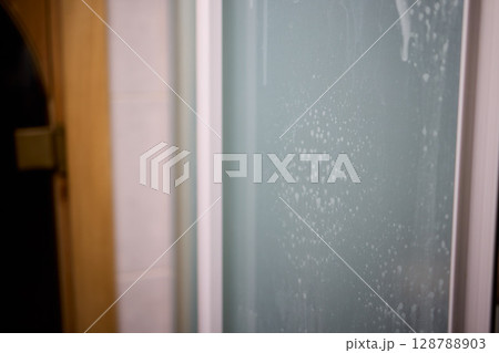 A person is cleaning a window with a spray bottle and cloth for clarity and shine 128788903
