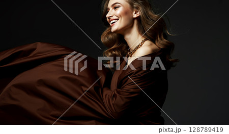 Elegant portrait of a smiling woman in luxurious brown attire, showcasing timeless beauty and style Elegant portrait of a smiling woman in luxurious brown attire, showcasing timeless beauty and style 128789419