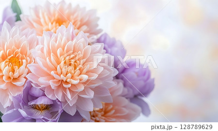 Beautiful arrangement of soft peach and lavender flowers on gentle blurred background 128789629