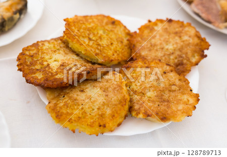 Potato pancakes with sour cream on white plate Potato pancakes with sour cream on white plate 128789713