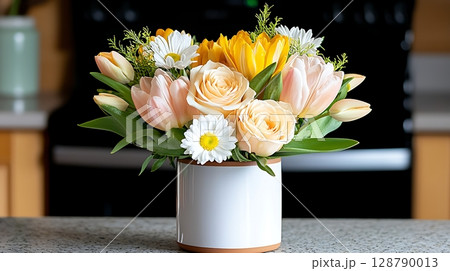 Beautiful spring bouquet with tulips, roses, and daisies on kitchen counter setting 128790013