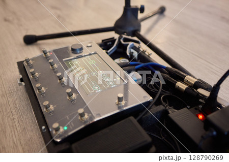 A Unique Collection of Guitar Effects Pedals Carefully Arranged on an Effect Board 128790269