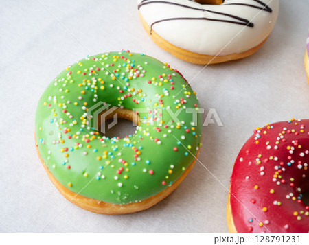 Donuts with different colorful icing designs on a white background. Donuts with different colorful icing designs on a white background. 128791231