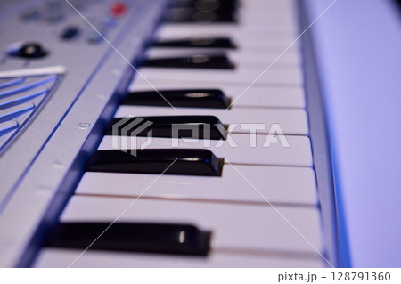 Hands play a keyboard in a modern studio, showcasing creativity and passion for music 128791360