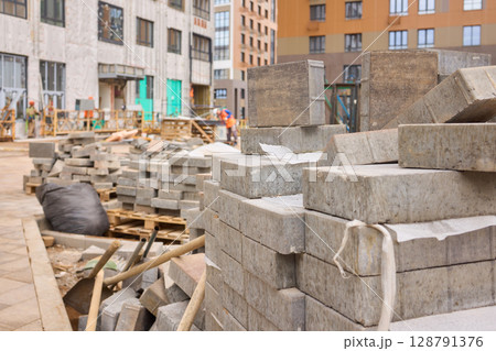 There are numerous piles of concrete debris observable at the busy construction site right now There are numerous piles of concrete debris observable at the busy construction site right now 128791376