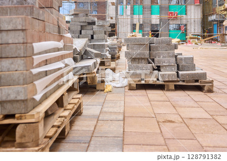 There are numerous piles of concrete debris observable at the busy construction site right now There are numerous piles of concrete debris observable at the busy construction site right now 128791382