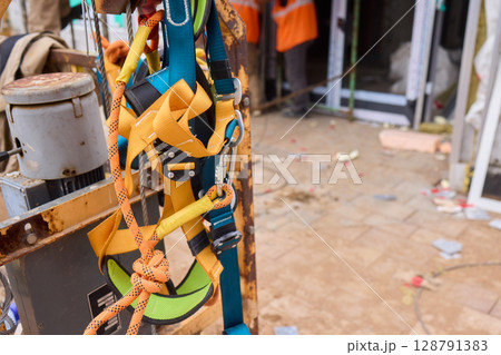 A vibrant and colorful equipment harness seen at a busy construction site, showcasing safety A vibrant and colorful equipment harness seen at a busy construction site, showcasing safety 128791383