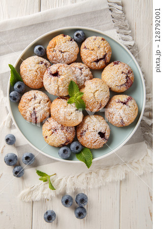 Cookies with blueberry filling sprinkled with powdered sugar closeup in the bowl. Vertical top view 128792001