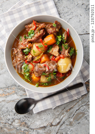 Indonesian Spiced Beef Stew Semur Daging closeup in the bowl on the table. Vertical top view Indonesian Spiced Beef Stew Semur Daging closeup in the bowl on the table. Vertical top view 128792011