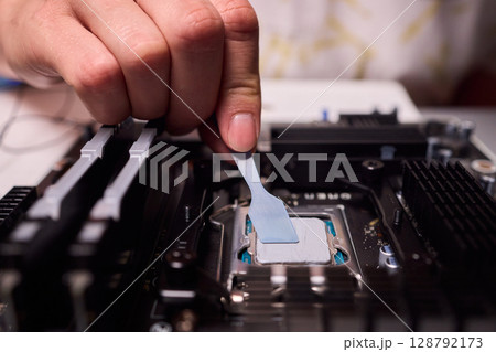 Carefully applying thermal paste on the CPU is essential for achieving optimal cooling performance Carefully applying thermal paste on the CPU is essential for achieving optimal cooling performance 128792173