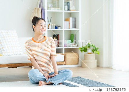 リビングでくつろぐ若い女性 リビングでくつろぐ若い女性 128792376