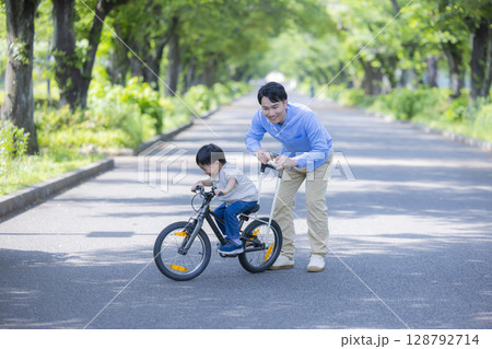 自転車に乗る練習をする親子　 128792714