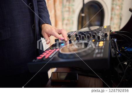 Witness the DJ mixing equipment performing live and in action at a vibrant music event 128792856
