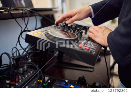 Witness the DJ mixing equipment performing live and in action at a vibrant music event 128792862